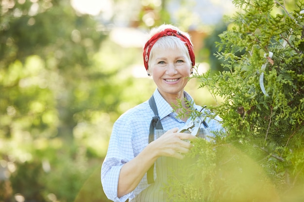 Mujer sonriente que trabaja en jardín