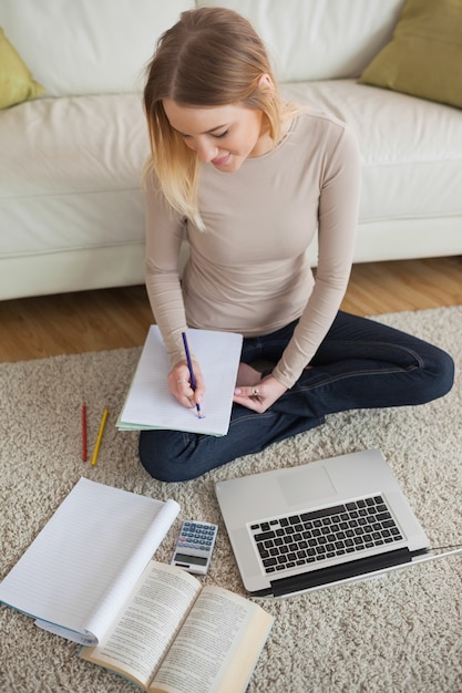 Foto mujer sonriente que trabaja en la tarea