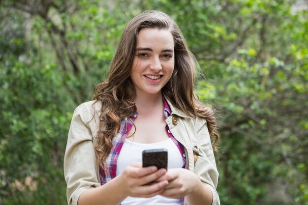 Mujer sonriente que usa smartphone