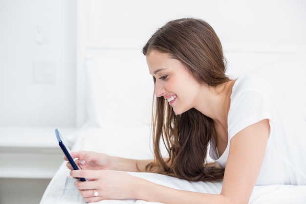 Mujer sonriente que usa la tableta en casa