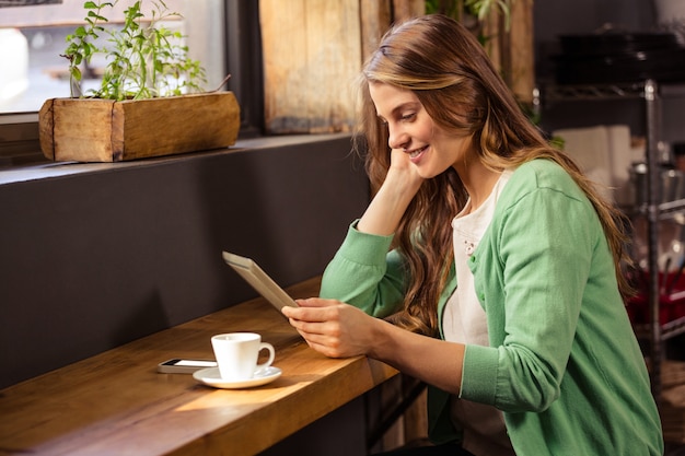 Mujer sonriente que usa una tableta