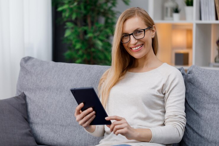 Mujer sonriente que usa la tableta