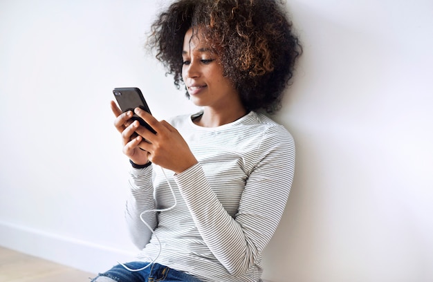 Mujer sonriente que usa un teléfono inteligente