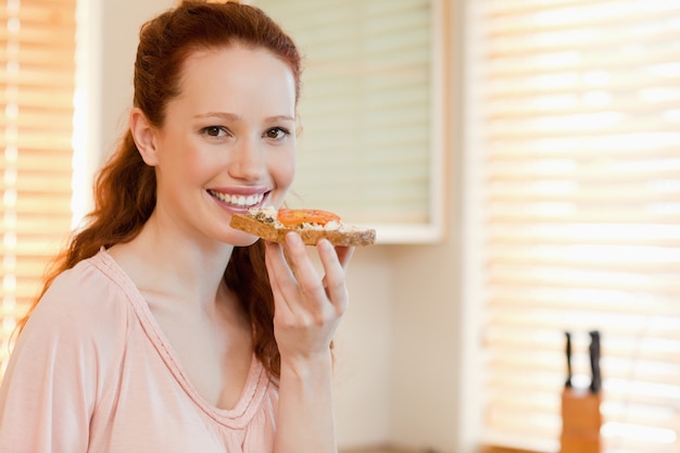 Mujer sonriente con una rebanada de pan