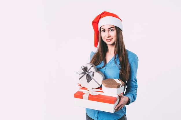 Mujer sonriente con regalos en gorro de Papá Noel aislado