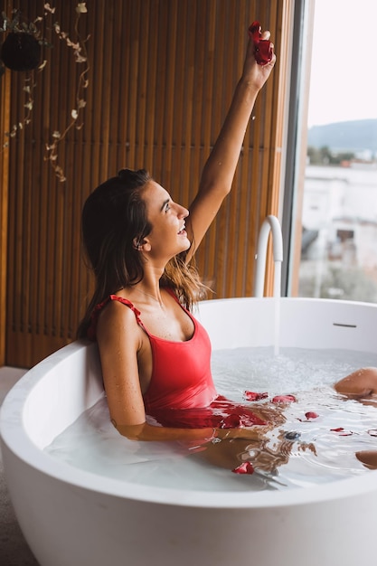 Foto mujer sonriente relajándose en la bañera en el baño