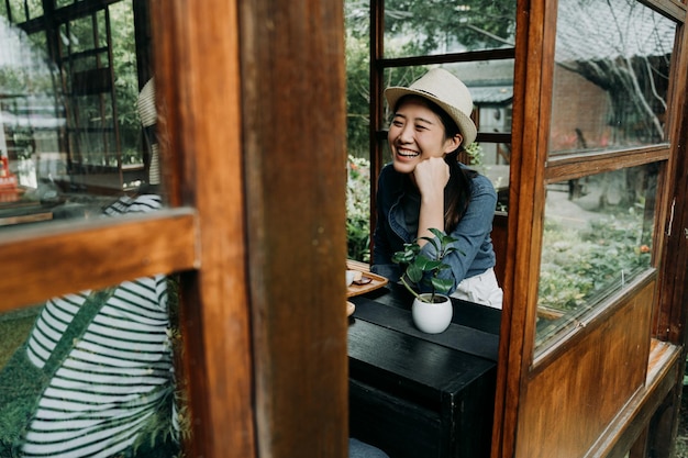 Mujer sonriente sentada bebiendo ceremonia del té