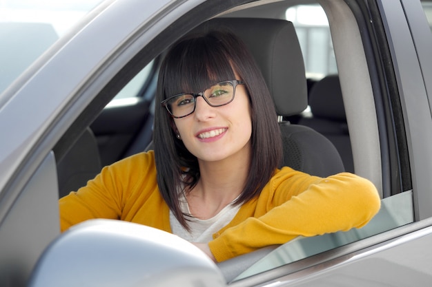 Mujer sonriente sentada en el coche