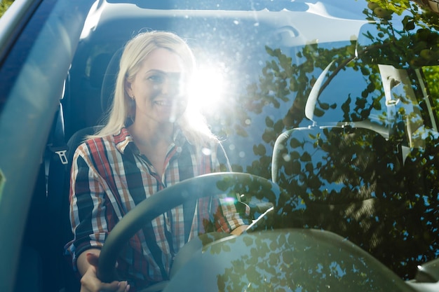 Foto mujer sonriente sentada en el coche