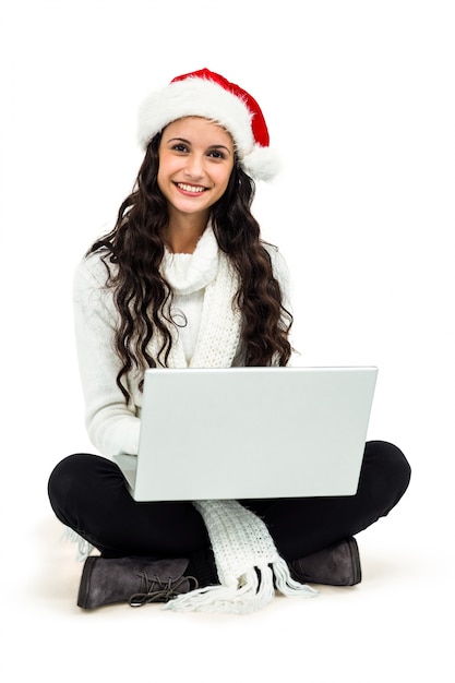 Mujer sonriente sentada en el piso usando la computadora portátil