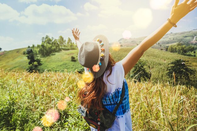 Foto mujer sonriente con sombrero de pie en el campo contra el cielo