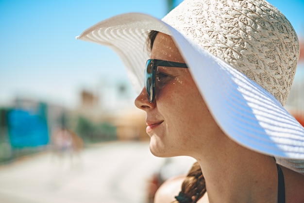 Mujer sonriente con un sombrero de verano y gafas de sol. Concepto de personas de vacaciones y viajes de verano