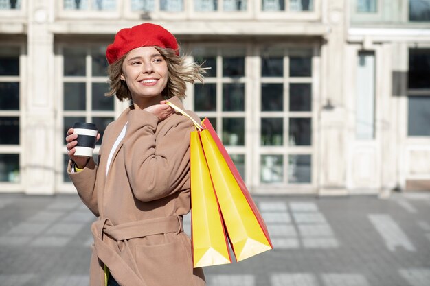 Mujer sonriente sosteniendo bolsas de compras tiro medio