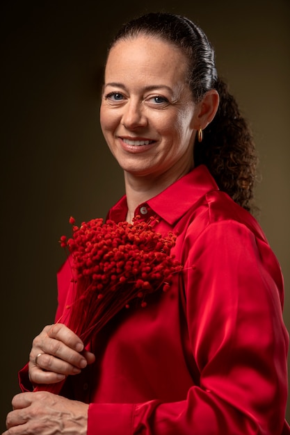 Foto mujer sonriente sosteniendo flores tiro medio