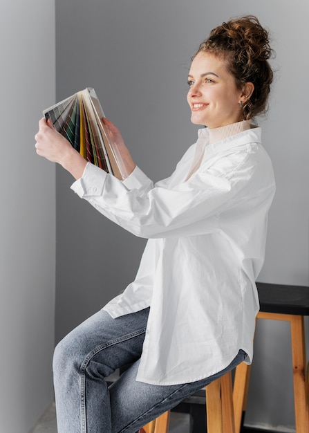 Foto mujer sonriente sosteniendo paleta de colores tiro medio