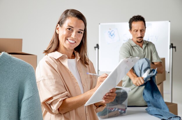 Foto mujer sonriente sosteniendo portapapeles tiro medio