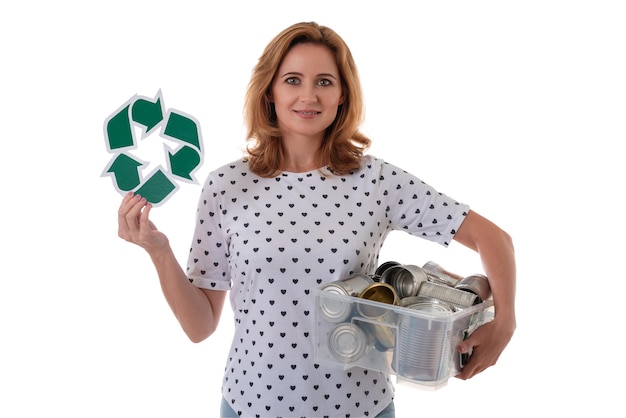 Foto mujer sonriente sosteniendo el símbolo de reciclaje y latas de aluminio en caja de plástico aislado sobre blanco