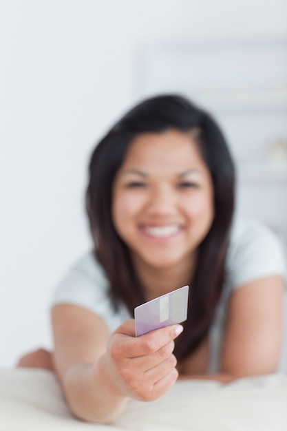 Mujer sonriente con una tarjeta de crédito