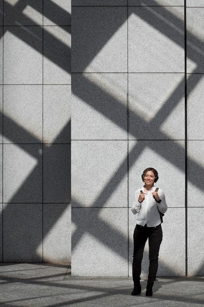 Foto mujer sonriente de tiro completo con auriculares