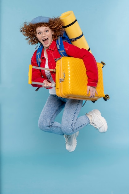 Mujer sonriente de tiro completo con equipaje