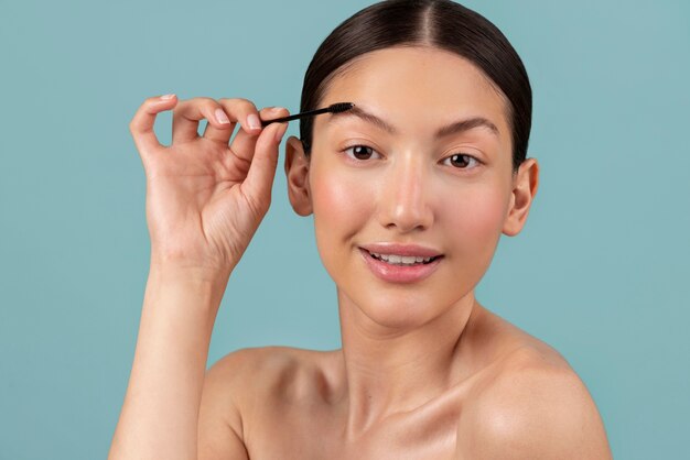 Foto mujer sonriente de tiro medio con cepillo para cejas