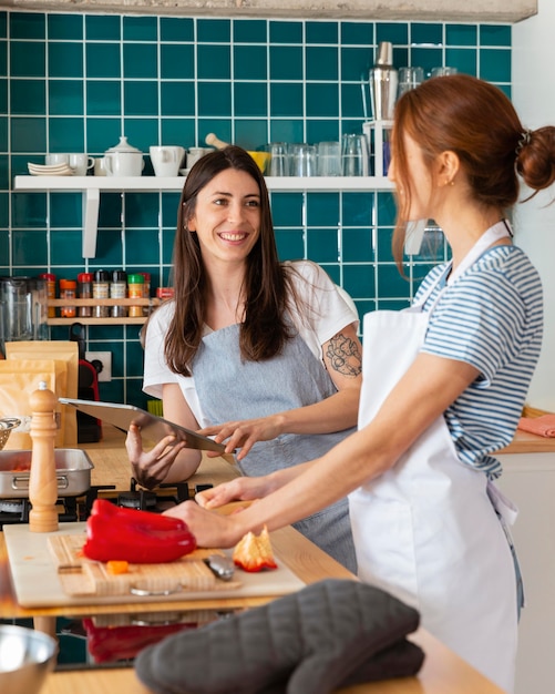 Foto mujer sonriente de tiro medio en la cocina