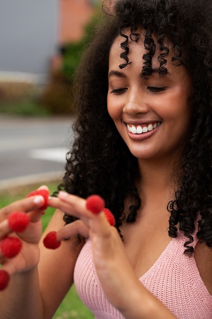 Foto mujer sonriente de tiro medio con frambuesas