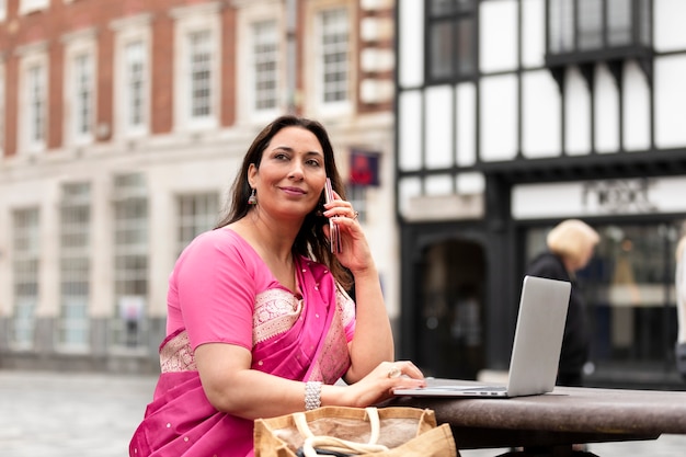 Mujer sonriente de tiro medio hablando por teléfono