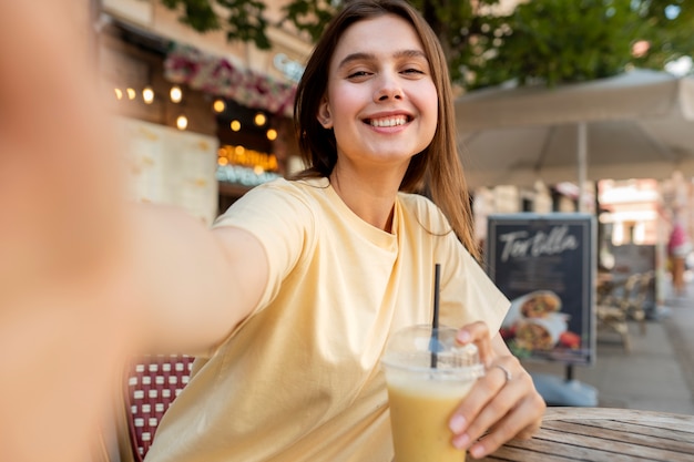 Mujer sonriente de tiro medio posando con bebida