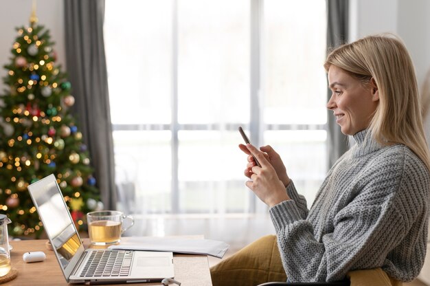 Foto mujer sonriente de tiro medio sosteniendo teléfono