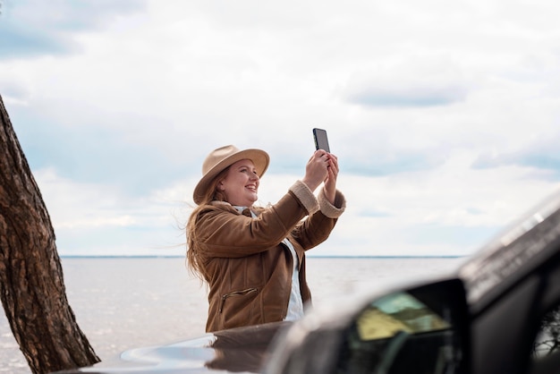 Foto mujer sonriente de tiro medio tomando fotos