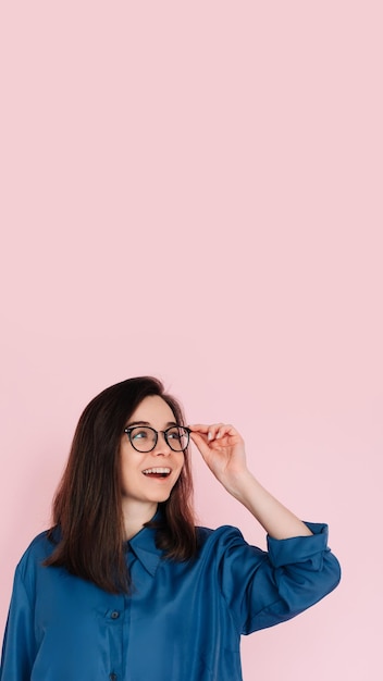 Mujer sonriente tocando gafas reflexionando y buscando ideas en un espacio vacío retrato aislado en