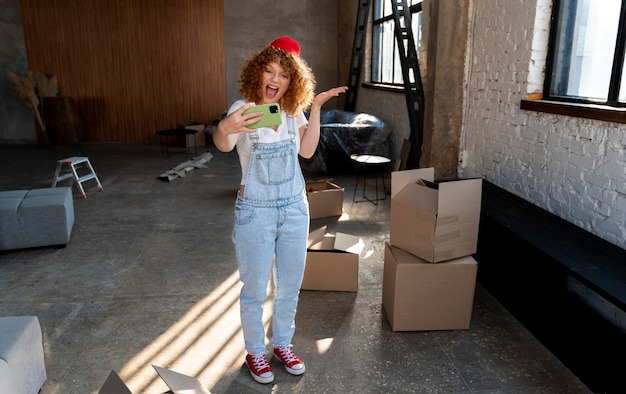 Mujer sonriente tomando selfie con smartphone en su nuevo hogar