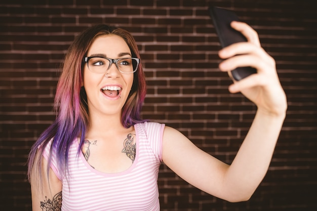 Mujer sonriente tomando selfie desde teléfono móvil