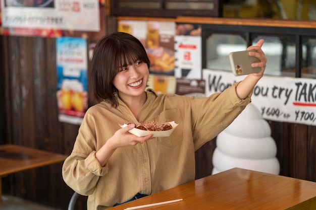 Foto mujer sonriente tomando selfie tiro medio