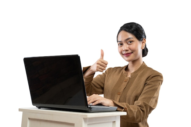 Mujer sonriente en uniforme de funcionario con laptop pulgar arriba