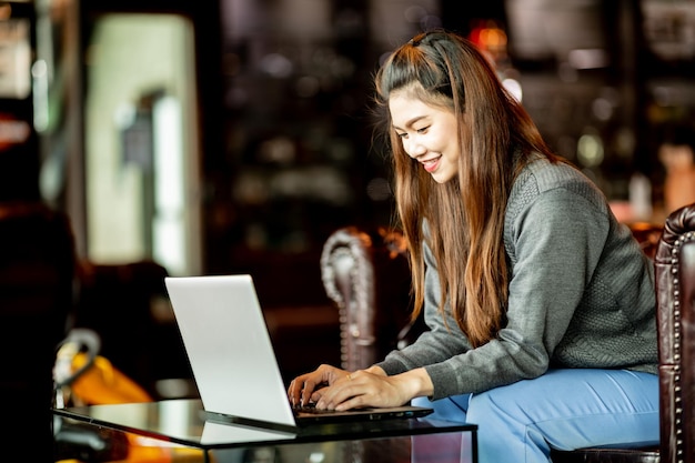 Mujer sonriente usando una computadora portátil en la mesa