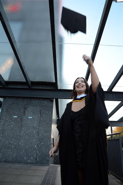 Foto mujer sonriente en vestido de graduación de pie al aire libre