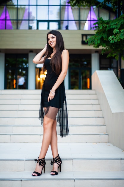 Mujer sonriente en vestido negro delgado