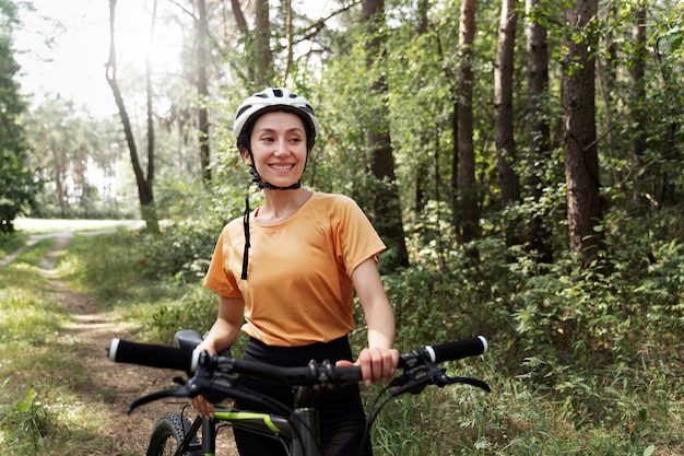 Mujer sonriente con vista frontal de bicicleta