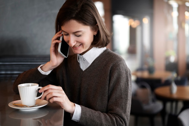 Foto mujer sonriente de vista lateral hablando por teléfono