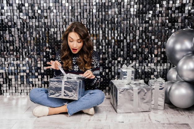 Foto la mujer se sorprende al desatar la cinta de regalo.