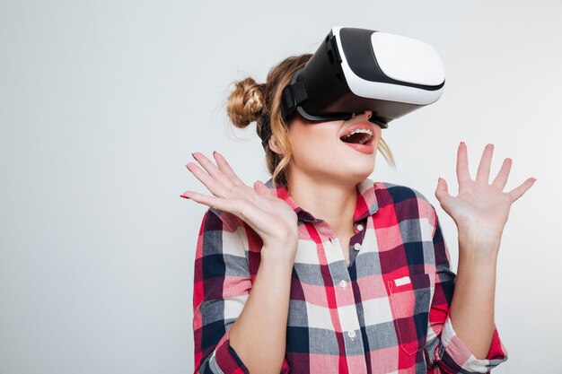 Mujer sorprendida en camisa con dispositivo de realidad virtual