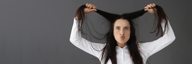Mujer sorprendida levantando su cabello retrato cómo hacer que el cabello sea grueso y fuerte concepto