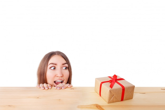 Foto mujer sorprendida mira una caja de regalo. navidad, navidad, invierno, concepto de felicidad.