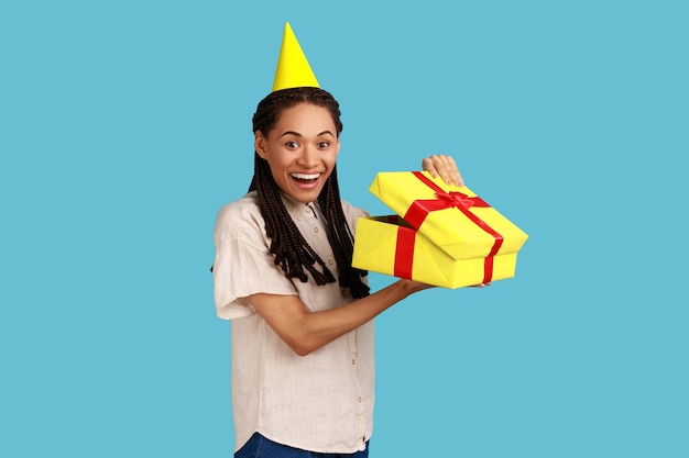 Mujer sorprendida mirando la caja de regalo abriendo el presente y mirando a la cámara con felicidad