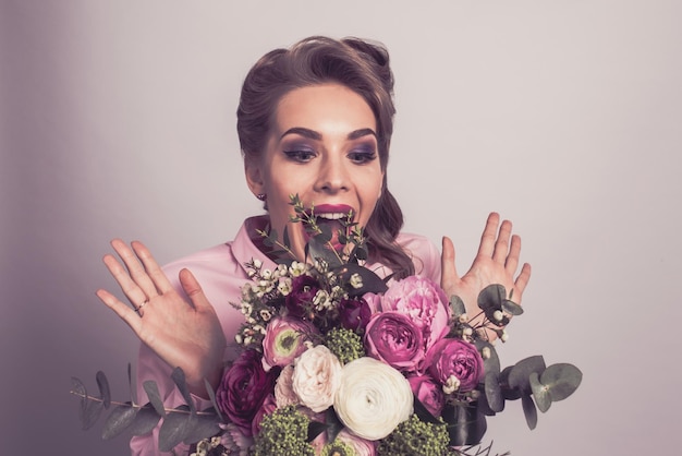 Mujer sorprendida con ramo de flores