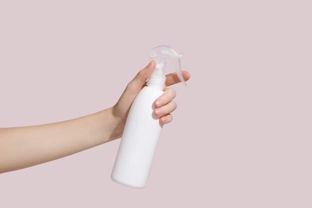 Mujer sostenga la botella de detergente en aerosol blanco en blanco Mockup