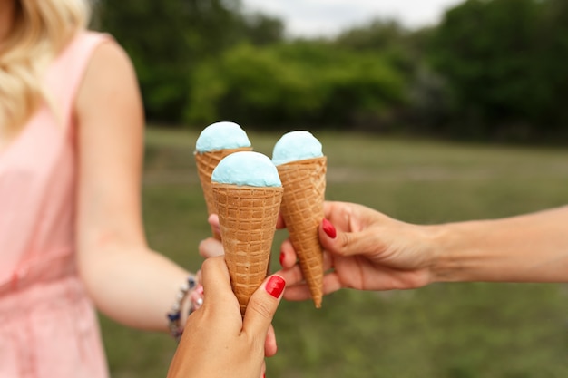 Mujer sostenga el cono de helado en la mano