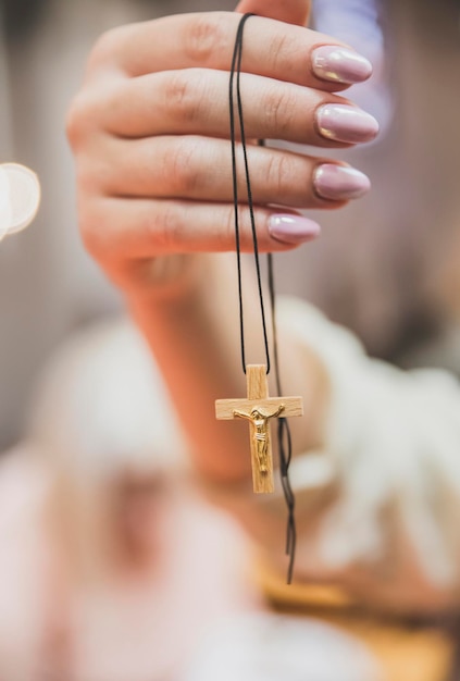 Mujer sostenga cruz de madera con crucifijo dorado en la mano